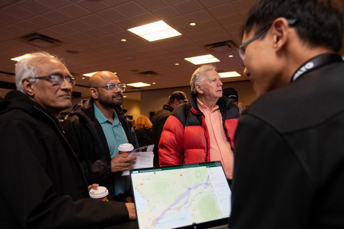 An Alto team member, with a tablet showing the corridor options between Ottawa and Toronto for the high-speed rail network, speaks with attendees during an open house held at the McDonnel Street Activity Centre in Peterborough on February 26, 2026. Peterborough is one of seven stops on the proposed network. (Photo: Jordan Lyall / kawarthaNOW)