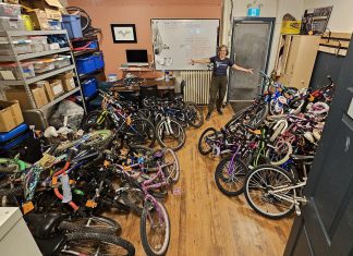 B!KE program manager Jean Greig with kids' bikes in need of refurbishing. Through the Kids Bike Build program, B!KE volunteers repair donated bikes and provide them to partner organizations who distribute them to children and families who may not otherwise have the means to obtain one. (Photo courtesy of B!KE)