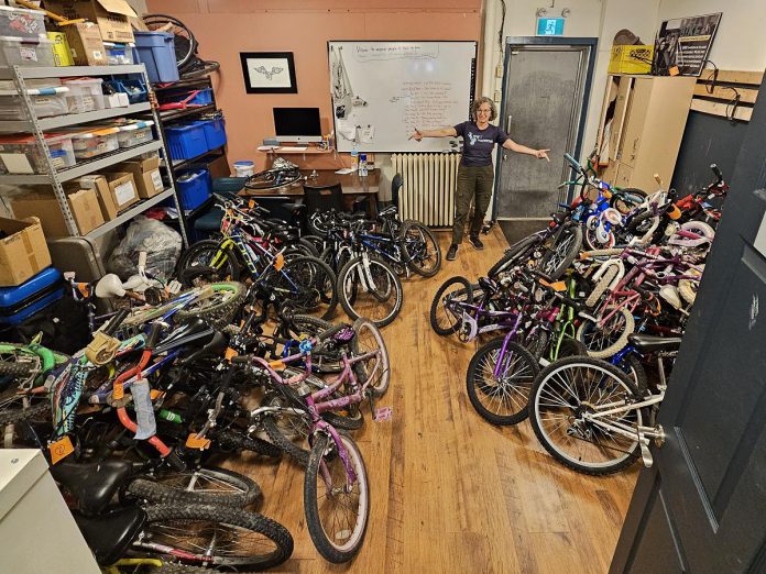 B!KE program manager Jean Greig with kids' bikes in need of refurbishing. Through the Kids Bike Build program, B!KE volunteers repair donated bikes and provide them to partner organizations who distribute them to children and families who may not otherwise have the means to obtain one. (Photo courtesy of B!KE)
