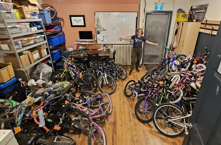 B!KE program manager Jean Greig with kids' bikes in need of refurbishing. Through the Kids Bike Build program, B!KE volunteers repair donated bikes and provide them to partner organizations who distribute them to children and families who may not otherwise have the means to obtain one. (Photo courtesy of B!KE)