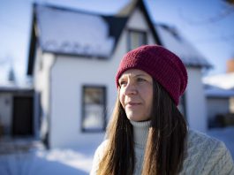 Kat Senyk in front of her upgraded home in Port Perry. Through her work experience leading exterior insulation and finish system (EIFS) overcladding projects, she was inspired to retrofit her own home's exterior insulation, contributing to a nearly 50 per cent reduction in energy use. (Photo: Adrian Merrit Smith)