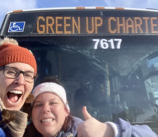 GreenUP education program coordinator Melanie Ellison and education and active transportation program manager Ashley Burnie Seeds in front of the Peterborough Transit bus that served as a classroom for Grade 7 and 8 students from St. Paul Catholic Elementary School in Lakefield on February 12, 2026. The students experienced hands-on education to familiarize them with riding transit safely and with confidence. (Photo: Melanie Ellison / GreenUP)