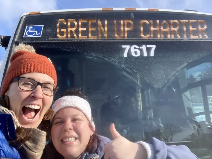 GreenUP education program coordinator Melanie Ellison and education and active transportation program manager Ashley Burnie Seeds in front of the Peterborough Transit bus that served as a classroom for Grade 7 and 8 students from St. Paul Catholic Elementary School in Lakefield on February 12, 2026. The students experienced hands-on education to familiarize them with riding transit safely and with confidence. (Photo: Melanie Ellison / GreenUP)