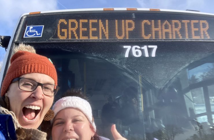 GreenUP education program coordinator Melanie Ellison and education and active transportation program manager Ashley Burnie Seeds in front of the Peterborough Transit bus that served as a classroom for Grade 7 and 8 students from St. Paul Catholic Elementary School in Lakefield on February 12, 2026. The students experienced hands-on education to familiarize them with riding transit safely and with confidence. (Photo: Melanie Ellison / GreenUP)