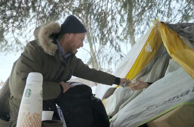 Chris Vyn, former outreach worker with One City Peterborough, provides food and supplies to a woman experiencing homelessness in 2022. (kawarthaNOW screenshot of One City Peterborough video)
