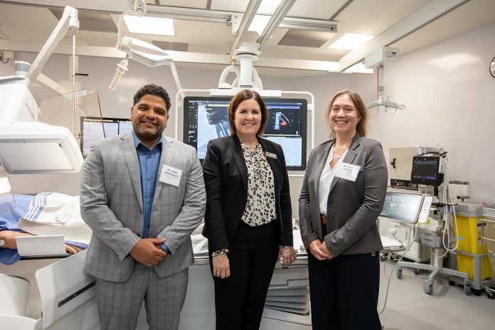 Peterborough Regional Health Centre (PRHC) interventional radiologist Dr. Fady Abdelsayed, PRHC Foundation president and CEO Lesley Heighway, and PRHC president and CEO Dr. Lynn Mikula stand in front of the state-of-the-art technology in the newest interventional radiology suite during a celebratory event held on December 9, 2025 at the regional hospital. The new suite and two existing and upgraded suites were made possible by a $6 million donor-funded investment, part of the PRHC Foundation's $70 million Campaign for PRHC. (Photo: Jordan Lyall / kawarthaNOW)