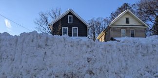 A windrow — the heavy ridge of snow pushed across the end of a driveway by passing plows — can be difficult to clear because it is densely packed and often mixed with ice and road treatment materials such as salt and sand, making it far heavier and harder to shovel, particularly for seniors and people with limited mobility. (Photo: Bruce Head / kawarthaNOW)
