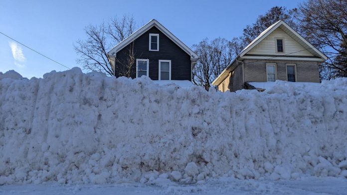 A windrow — the heavy ridge of snow pushed across the end of a driveway by passing plows — can be difficult to clear because it is densely packed and often mixed with ice and road treatment materials such as salt and sand, making it far heavier and harder to shovel, particularly for seniors and people with limited mobility. (Photo: Bruce Head / kawarthaNOW)