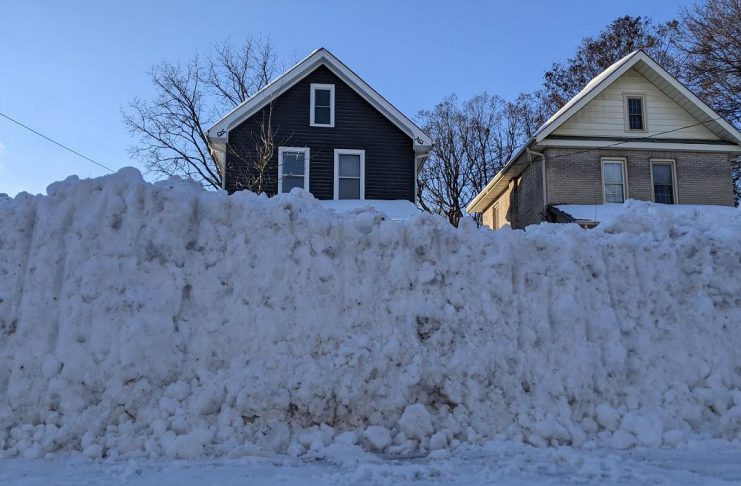 A windrow — the heavy ridge of snow pushed across the end of a driveway by passing plows — can be difficult to clear because it is densely packed and often mixed with ice and road treatment materials such as salt and sand, making it far heavier and harder to shovel, particularly for seniors and people with limited mobility. (Photo: Bruce Head / kawarthaNOW)