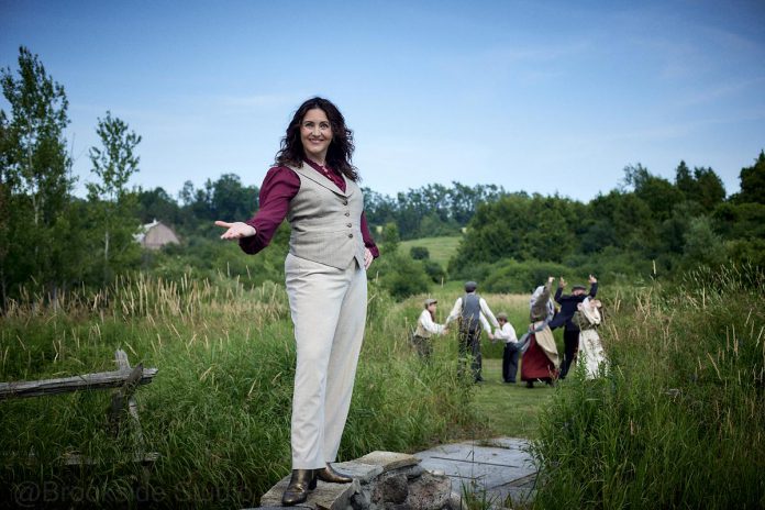"Wild Irish Geese" playwright and actor Megan Murphy with Padrick Wilson, Sebastian Sage, Jasper Chesser, Lindsay Wilson, Paul Crough, and Indigo Chesser in the background, in a promotional photo for the world premiere of the play at 4th Line Theatre in 2025. (Photo: Wayne Eardley, Brookside Studio)