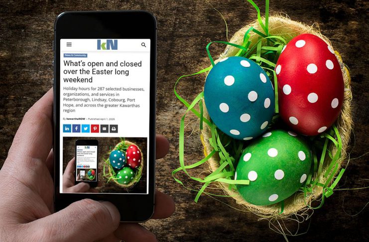 A mobile phone showing kawarthaNOW's Easter 2026 holiday hours over a table with a basket of decorated Easter eggs. (Photo: kawarthaNOW)
