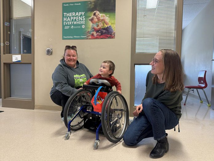 Arthur's guardian Delaney (left) and Five Counties Children Centre physiotherapist Kyrie watch the bubbles floating down the hall during one of the two-year-old boy's therapy sessions at the children's treatment centre in Peterborough. (Photo courtesy of Five Counties Children's Centre)