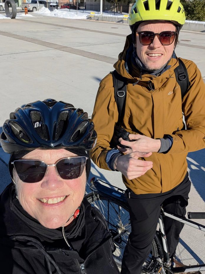Brett Throop, GreenUP's active new transportation program coordinator, pictured with his mom Sue as they get ready to roll out for one of B!KE's Snow Pokes rides in February 2026. (Photo: Sue Throop)