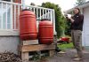 Installing a rain barrel is a simple way to collect water for outdoor use while reducing the amount of water entering local storm sewers. Rain barrels can be connected in a series to detain and collect even more runoff. GreenUP landscape program manager Hayley Goodchild demonstrates how to link rain barrels together at a residential property. (Photo: Jessica Todd / GreenUP)