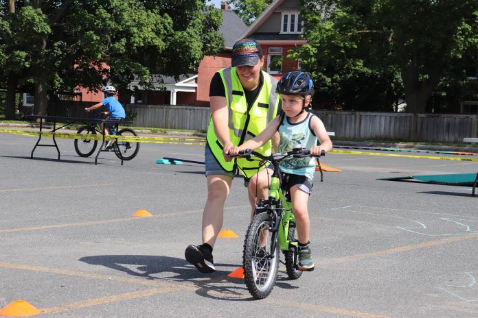 GreenUP interim executive director Natalie Stephenson supports a young cyclist during a community Let's Bike! cycling pop-up hosted at the Balsillie Family YMCA. Supported by GreenUP, Active School Travel Peterborough hosts events to promote the use of active and sustainable transportation for the daily trip to school. As a charitable organization, GreenUP relies on community donations to maintain the quality and diversity of their programs. (Photo: GreenUP)