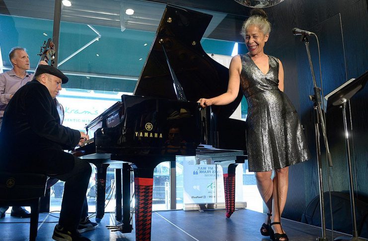 Juno award-winning Canadian jazz vocalist Molly Johnson performing with pianist Robi Botos and bassist Mike Downes at the 2019 Kensington Market Jazz Festival in 2019. Johnson will be performing with Botos and Downes along with drummer David Direnzo at Market Hall Performing Arts Centre in downtown Peterborough on April 26, 2026 as part of the annual International Jazz Day Peterborough celebrations. (Photo via Tom's Place website)