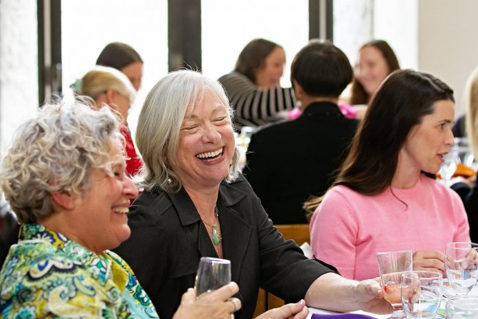 Luminary Awards co-founder Karen August (middle) laughs with Peterborough and the Kawarthas Chamber of Commerce board chair Susan Dunkley (left) at a table with Peterborough MP Emma Harrison (right) during the inaugural Luminary Awards celebration on May 8, 2025 at the Great Hall of Trent University's Champlain College. (Photo: Jordan Lyall Photography)