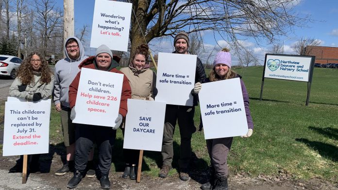 Parents and supporters at the Northview Community Campus in Peterborough, home to Northview Community Church and the Northview Daycare and Nursery School (Northview DaySchool), during an awareness event on April 19, 2026 with signs urging the church's board to reconsider the July 31 eviction deadline for Northview DaySchool and grant an extension. (Photo: Bethan Bates / kawarthaNOW)