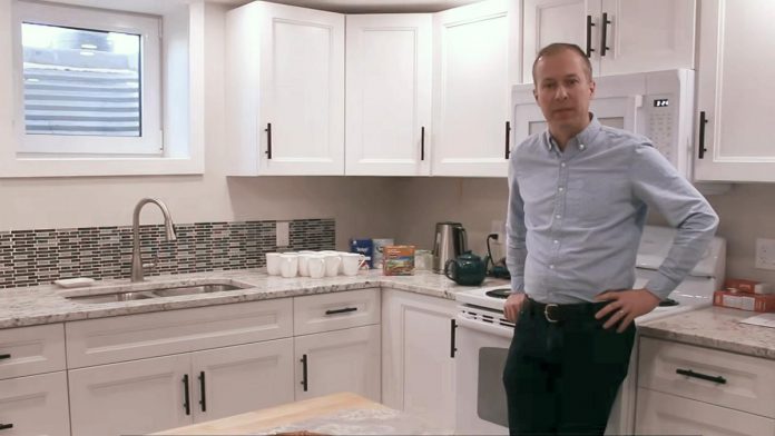 One City Peterborough's director of property development Michael Vanderherberg in the kitchen of a self-contained basement apartment, which is part of a partnership with Peterborough Action for Tiny Homes to construct additional rental units (ARUs) to provide supportive housing options for tenants of residential properties owned by One City. (kawarthaNOW screenshot of One City Peterborough video)