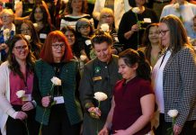 Peterborough Community Health Centre executive director Ashley Safar, former YWCA Peterborough Haliburton executive director Lynn Zimmer, Senator Marilou McPhedran, Maryam Monsef's niece Ellia, and Kawartha Financial Services senior manager of commercial solutions Darlene Weales hold white roses in memory of the late Peterborough civic leader Ann Farquharson during the "A Conversation About The Status of Women In Our Community" event at Market Hall in downtown Peterborough on March 31, 2026, presented by Maryam Monsef's organization ONWARD in partnership with the Peterborough and Kawarthas Chamber of Commerce, which featured 16 female speakers engaging in conversation on important issues related to women's health, resilience, and leadership. (Photo: Jordan Lyall / kawarthaNOW)