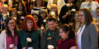 Peterborough Community Health Centre executive director Ashley Safar, former YWCA Peterborough Haliburton executive director Lynn Zimmer, Senator Marilou McPhedran, Maryam Monsef's niece Ellia, and Kawartha Financial Services senior manager of commercial solutions Darlene Weales hold white roses in memory of the late Peterborough civic leader Ann Farquharson during the "A Conversation About The Status of Women In Our Community" event at Market Hall in downtown Peterborough on March 31, 2026, presented by Maryam Monsef's organization ONWARD in partnership with the Peterborough and Kawarthas Chamber of Commerce, which featured 16 female speakers engaging in conversation on important issues related to women's health, resilience, and leadership. (Photo: Jordan Lyall / kawarthaNOW)
