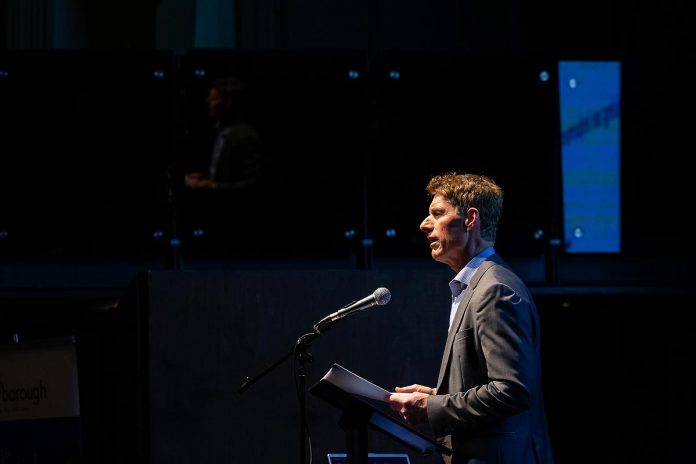 Peterborough city clerk John Kennedy introduces Nigel Bellchamber at Market Hall Performing Arts Centre in downtown Peterborough during the "So, You Want to Run for Council - Candidate 101 Information Session" on March 31, 2026. The session was presented by the City of Peterborough along with the eight townships of Peterborough County. (Photo: Jordan Lyall / kawarthaNOW)