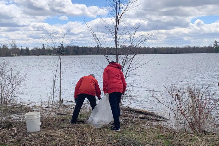 Two of the 35-plus volunteers who participated in an Earth Day clean-up of Rogers Cove park in Peterborough on April 19, 2026, picking up litter along the Little Lake waterfront and in the park. The clean-up was organized by Becca Durbin, owner of Salix Environmental Consulting, in partnership with Clean Up Peterborough and the City of Peterborough. (Photo: Bethan Bates / kawarthaNOW)