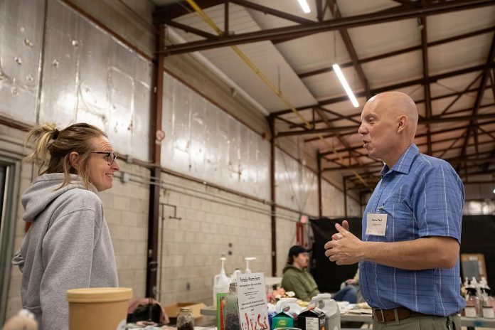 Clean Up Peterborough founder Steve Paul speaks with Our Little Wormery owner Callie Downer, one of the 20 exhibitors at the spring RE:Connect event organized by Clean Up Peterborough at the Morrow Building on April 15, 2026. (Photo: Jordan Lyall / kawarthaNOW)