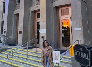 Peterborough resident Brooke Roberts holding a photo of her late daughter Sofie while standing outside Peterborough City Hall on May 2, 2026, when it was lit up in grey, yellow, and teal in honour of Brain Cancer Awareness Month. Brooke is an ambassador for Brain Cancer Canada, a national charity that works to raise awareness and bridge the gap in funding for brain cancer research and access. (Photo courtesy of the Roberts family)
