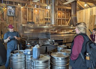 The Local Advantage with Peterborough County: Red Mill Maple Syrup brings Quebec’s love for maple syrup to The Kawarthas Red Mill Maple Syrup co-owner Sebastien Poulin (left) leads a tour about maple syrup production at the Millbrook producer's sugar shack. He and his wife Julie Vallieres, who were both raised in a region of Quebec well-known for maple syrup, have been producing maple syrup at their 10-acre property since 2011 and launched the Red Mill Maple Syrup brand in 2017. The business is a member of Kawartha Choice FarmFresh to promote their products to consumers and is interested in participating in the Kawartha Local Food Wholesale program to reach more wholesale buyers. (Photo courtesy of Red Mill Maple Syrup)
