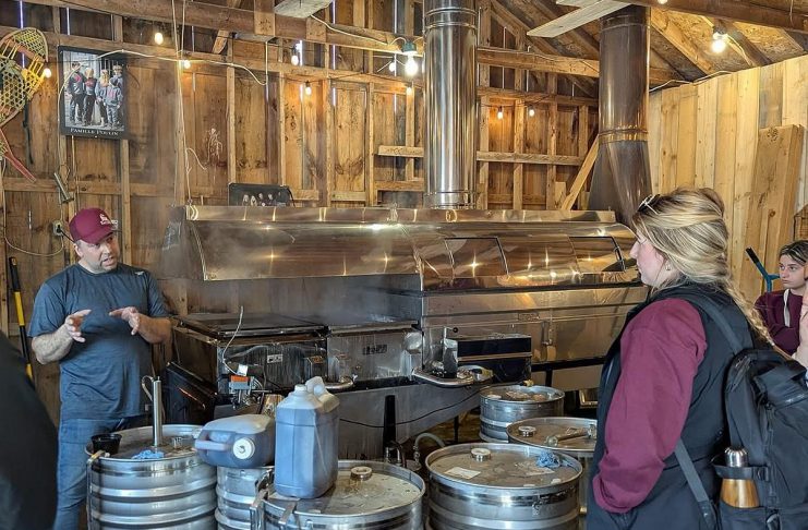 The Local Advantage with Peterborough County: Red Mill Maple Syrup brings Quebec’s love for maple syrup to The Kawarthas Red Mill Maple Syrup co-owner Sebastien Poulin (left) leads a tour about maple syrup production at the Millbrook producer's sugar shack. He and his wife Julie Vallieres, who were both raised in a region of Quebec well-known for maple syrup, have been producing maple syrup at their 10-acre property since 2011 and launched the Red Mill Maple Syrup brand in 2017. The business is a member of Kawartha Choice FarmFresh to promote their products to consumers and is interested in participating in the Kawartha Local Food Wholesale program to reach more wholesale buyers. (Photo courtesy of Red Mill Maple Syrup)