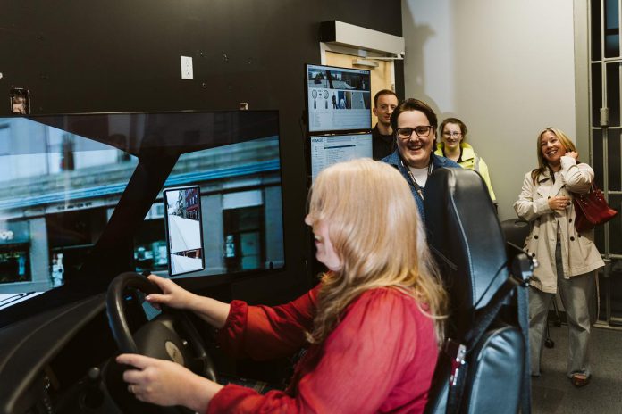 A guest at Fleming College's Community Impact & Appreciation Event at the Sutherland Campus in Peterborough on April 30, 2026 tries out a simulator. Fully immersive lab spaces with 360-degree projections and customizable interactive touchpoints provide students preparing for careers in firefighting, nursing, and policing with practice scenarios they will encounter in the real world. (Photo: Mary Zita Payne for Fleming College)