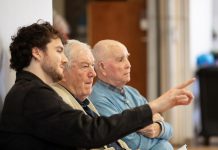 ‘The Kid from Simcoe Street’ tells the real-life story of James Clarke overcoming adversity in wartime Peterborough Retired Ontario Superior Court Justice and poet James Clarke (middle) watching a rehearsal on April 28, 2026 of Trent Valley Archives Theatre's "The Kid from Simcoe Street," based on his 2012 memoir of the same title, along with his grandson and script consultant David Francis Clarke and his old friend Murray Byrne, who he was recently reunited with after 73 years and who makes a cameo in the play, which is being staged at Market Hall Performing Arts Centre for four performances from June 4 to 7, 2026. (Photo: Jordan Lyall Photography)