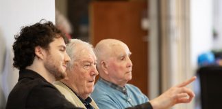 Retired Ontario Superior Court Justice and poet James Clarke (middle) watching a rehearsal on April 28, 2026 of Trent Valley Archives Theatre's "The Kid from Simcoe Street," based on his 2012 memoir of the same title, along with his grandson and script consultant David Francis Clarke and his old friend Murray Byrne, who he was recently reunited with after 73 years and who makes a cameo in the play, which is being staged at Market Hall Performing Arts Centre for four performances from June 4 to 7, 2026. (Photo: Jordan Lyall Photography)