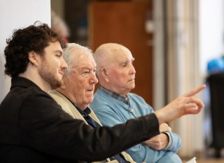 Retired Ontario Superior Court Justice and poet James Clarke (middle) watching a rehearsal on April 28, 2026 of Trent Valley Archives Theatre's "The Kid from Simcoe Street," based on his 2012 memoir of the same title, along with his grandson and script consultant David Francis Clarke and his old friend Murray Byrne, who he was recently reunited with after 73 years and who makes a cameo in the play, which is being staged at Market Hall Performing Arts Centre for four performances from June 4 to 7, 2026. (Photo: Jordan Lyall Photography)