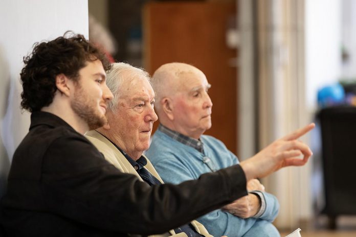 Retired Ontario Superior Court Justice and poet James Clarke (middle) watching a rehearsal on April 28, 2026 of Trent Valley Archives Theatre's "The Kid from Simcoe Street," based on his 2012 memoir of the same title, along with his grandson and script consultant David Francis Clarke and his old friend Murray Byrne, who he was recently reunited with after 73 years and who makes a cameo in the play, which is being staged at Market Hall Performing Arts Centre for four performances from June 4 to 7, 2026. (Photo: Jordan Lyall Photography)