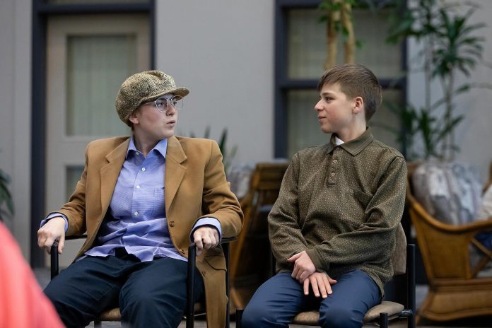 June Govier as Pete and Charlie Harris as Jimmy Clarke during a special preview dress rehearsal of Trent Valley Archives Theatre's "The Kid from Simcoe Street" at Canterbury Gardens in Peterborough on May 28, 2026. In this scene, the mischievious Pete leads his friend Jimmy astray at St. Peter Cathedral by asking Jimmy to hear his confession. (Photo: Jordan Lyall Photography)