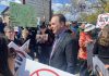 Federal transport minister Steven MacKinnon wades into a crowd of people protesting against the Alto high-speed rail project outside the office of the Peterborough and Kawarthas Chamber of Commerce after he arrived to speak at an event hosted by the Chamber on May 8, 2026. (Photo: Paul Rellinger / kawarthaNOW)