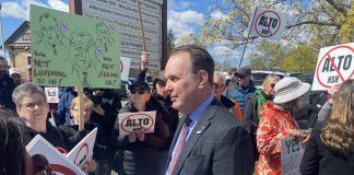 Federal transport minister Steven MacKinnon wades into a crowd of people protesting against the Alto high-speed rail project outside the office of the Peterborough and Kawarthas Chamber of Commerce after he arrived to speak at an event hosted by the Chamber on May 8, 2026. (Photo: Paul Rellinger / kawarthaNOW)