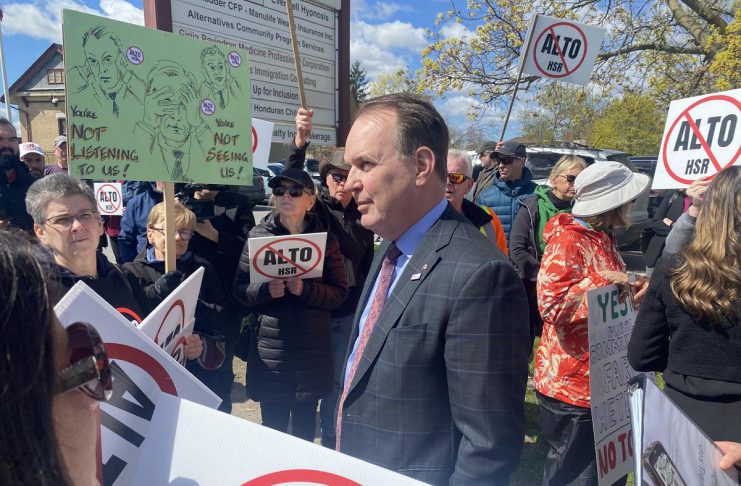 Federal transport minister Steven MacKinnon wades into a crowd of people protesting against the Alto high-speed rail project outside the office of the Peterborough and Kawarthas Chamber of Commerce after he arrived to speak at an event hosted by the Chamber on May 8, 2026. (Photo: Paul Rellinger / kawarthaNOW)