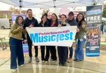 The Peterborough Musicfest team, led by executive director Tracey Randall (middle), celebrating the lineup of free-admission summer outdoor concerts for the festival's 39th season during an announcement event at Quaker Foods City Square in downtown Peterborough on May 13, 2026. (Photo: Paul Rellinger / kawarthaNOW)