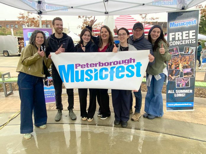 The Peterborough Musicfest team, led by executive director Tracey Randall (middle), celebrating the lineup of free-admission summer outdoor concerts for the festival's 39th season during an announcement event at Quaker Foods City Square in downtown Peterborough on May 13, 2026. (Photo: Paul Rellinger / kawarthaNOW) The Peterborough Musicfest team, led by executive director Tracey Randall (middle), celebrating the lineup of free-admission summer outdoor concerts for the festival's 39th season during an announcement event at Quaker Foods City Square in downtown Peterborough on May 13, 2026. (Photo: Paul Rellinger / kawarthaNOW)