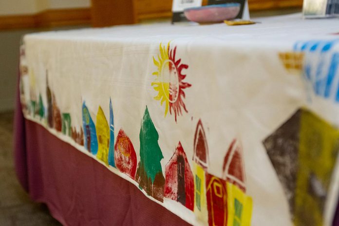 A tablecloth created in partnership with One City Peterborough residents that was on display during an event to discuss the non-profit organization's housing strategy at Knights of Columbus Hall on May 12, 2026. (Photo: Jordan Lyall / kawarthaNOW)