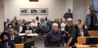 An irate member of the public shouts at councillors during a debate on a winter shelter response plan for homelessness at city council's general committee meeting on May 25, 2026. (kawarthaNOW screenshot of City of Peterborough video)