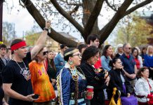 Residents of Nogojiwanong-Peterborough gathered at Peterborough City Hall on May 5, 2026 to commemorate Red Dress Day at an event led by the Urban Indigenous Working Group in collaboration with the City of Peterborough. May 5 has been recognized as the National Day of Awareness for Missing and Murdered Indigenous Women, Girls, and 2SLGBTQI+ People (MMIWG2S+) since 2010. (Photo: Jordan Lyall / kawarthaNOW)