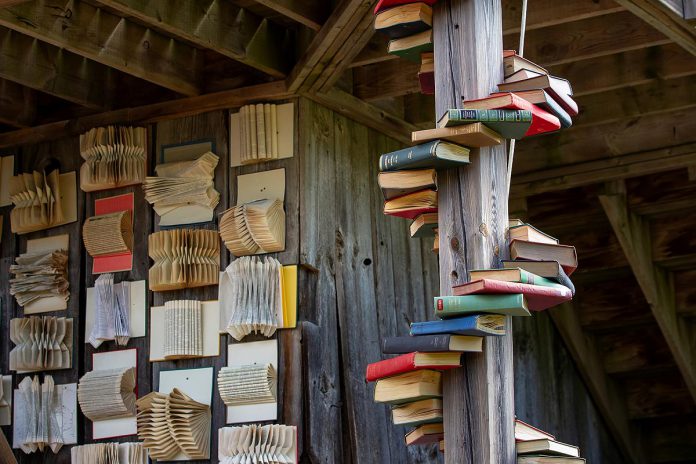 Part of the set of Leanna Brodie's play "Schoolhouse" during a media day event on June 17, 2026 hosted by 4th Line Theatre at Winslow Farm near Millbrook. 4th Line Theatre put a call out to community members to donate old hardcover books, which set designer Michelle Chesser repurposed in a visually striking way. (Photo: Jordan Lyall / kawarthaNOW)