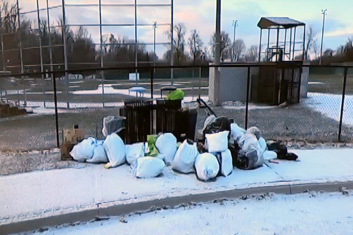 This photo of bags of garbage dumped at James Stevenson Park in Peterborough's East City was part of a city staff presentation on the Clean Streets Peterborough initiative to city council meeting as general committee on May 25, 2026. (kawarthaNOW screenshot of City of Peterborough video)