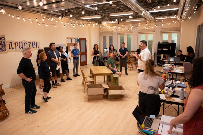 Capitol Theatre artistic director Rob Kempson (right) directing the cast during a rehearsal of the Capitol Theatre's production of "Come From Away" at the historic venue in Port Hope from July 10 to August 9, 2026. (Photo: Sam Moffatt)