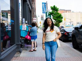 Peterborough Downtown Business Improvement Area (DBIA) executive director Nour Mazloum walks downtown wearing a T-shirt with the original DBIA logo from when the organization was founded in 1981. The merchandise is being rolled out as part of a celebration for the organization's 45-year anniversary, just as Mazloum reflects on her two years at its helm. (Photo courtesy of Peterborough DBIA)