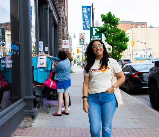 Peterborough Downtown Business Improvement Area (DBIA) executive director Nour Mazloum walks downtown wearing a T-shirt with the original DBIA logo from when the organization was founded in 1981. The merchandise is being rolled out as part of a celebration for the organization's 45-year anniversary, just as Mazloum reflects on her two years at its helm. (Photo courtesy of Peterborough DBIA)
